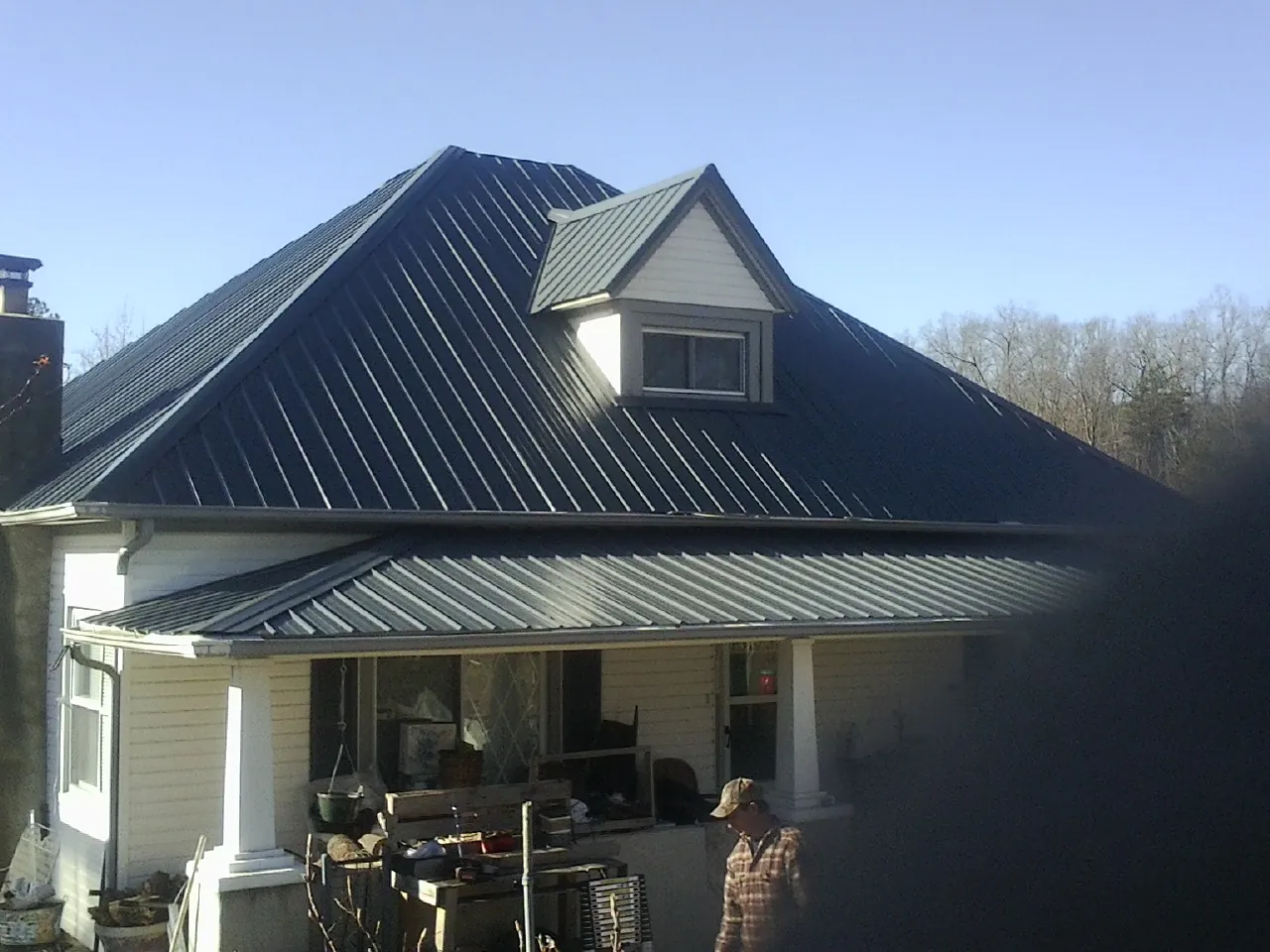 Dark blue standing seam metal roof with a dormer above a front porch in Morrilton