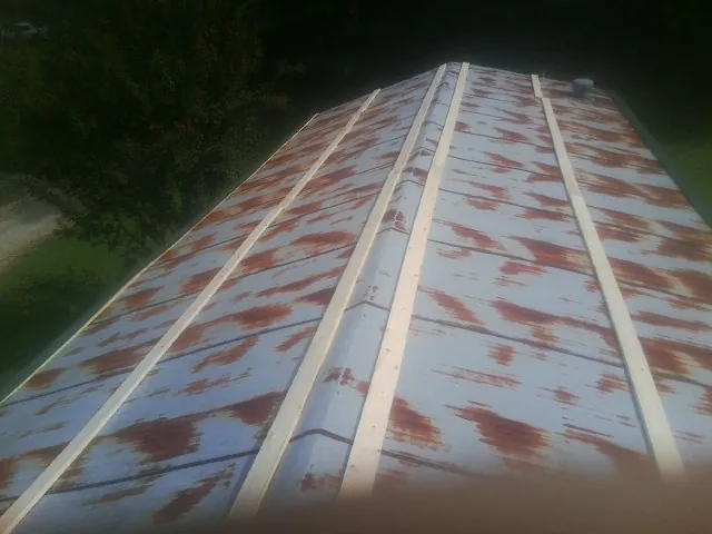 Rusted metal roof panels with new wood purlins before replacement — Storm Damage Roof Repair in Morrilton by Roofing Brothers
