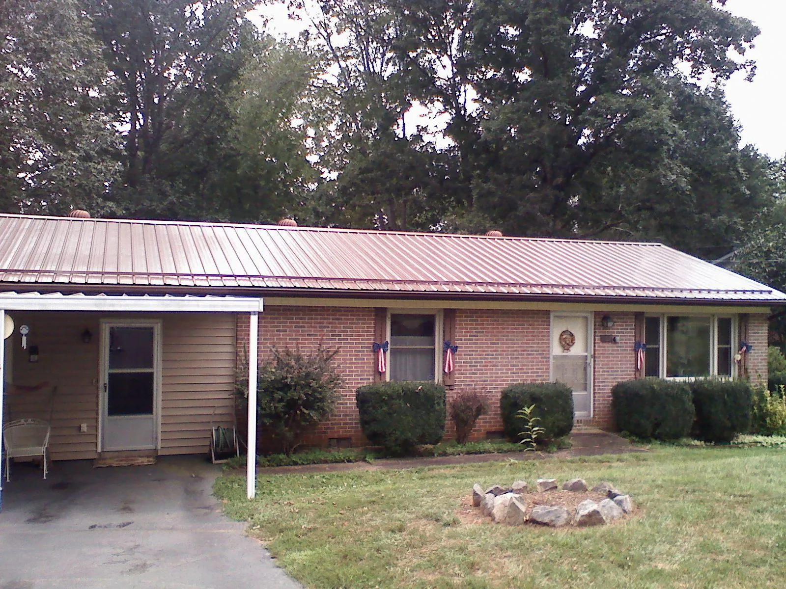 Bronze metal roof and carport on a brick ranch home — Roof Repair work by our crew in Morrilton