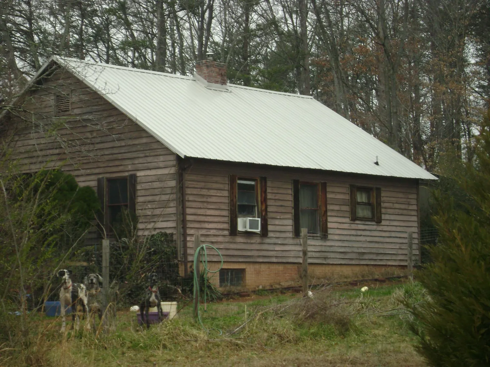 White metal roof on an old wood sided farmhouse, from a Metal Roof Installation job in Morrilton